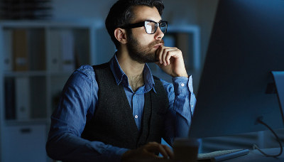 man thinking in front of computer screen
